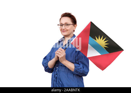 Antigua e Barbuda bandiera. Bel ritratto di mezza età lady 40 50 anni tenendo un grande bandiera isolati su sfondo bianco. Foto Stock
