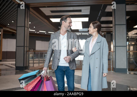 Moglie guardando il suo amorevole uomo mentre sensazione grati dopo il weekend shopping Foto Stock