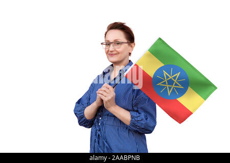 Etiopia bandiera. Donna che mantiene bandiera etiope. Bel ritratto di mezza età lady 40 50 anni tenendo un grande bandiera isolati su sfondo bianco. Foto Stock