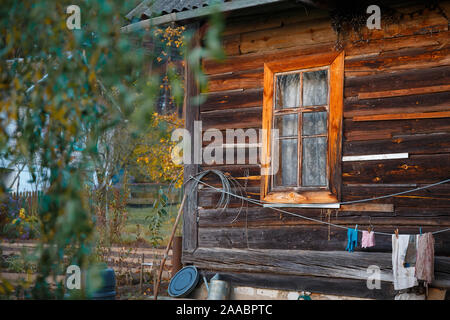 Finestra e parte di una vecchia casa rurale. La vita di campagna in una vecchia casa in legno in Russia. Foto Stock