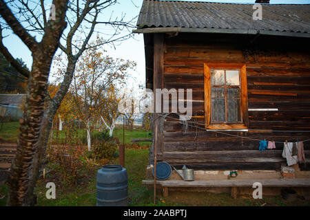 Finestra e parte di una vecchia casa rurale. La vita di campagna in una vecchia casa in legno in Russia. Foto Stock