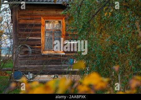 Finestra e parte di una vecchia casa rurale. La vita di campagna in una vecchia casa in legno in Russia. Foto Stock