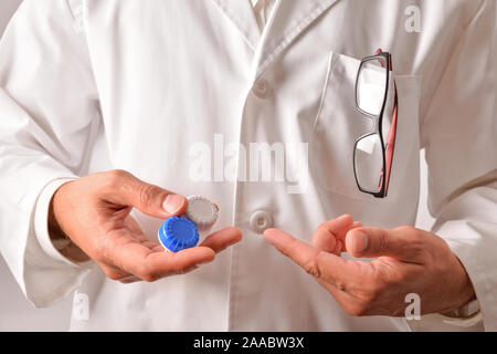 Ottico con mantello bianco che mostra una custodia per lenti a contatto. Composizione orizzontale. Vista frontale Foto Stock