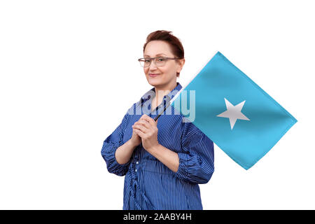 Bandiera della Somalia. Donna che mantiene bandiera. Bel ritratto di mezza età lady 40 50 anni tenendo un grande bandiera isolati su sfondo bianco. Foto Stock