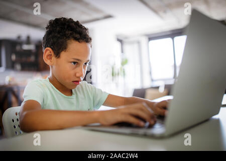 Ragazzo di trascorrere del tempo con i notebook e tecnologia moderna Foto Stock