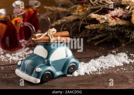 Retrò giocattolo auto porta bastoncini di cannella. Natale o Capodanno concetto. Vin brulé bere ancora in una vita. Close-up. Spazio di copia Foto Stock