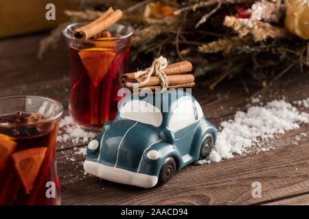 Retrò giocattolo auto porta bastoncini di cannella. Natale o Capodanno concetto. Vin brulé bere ancora in una vita. Close-up. Spazio di copia Foto Stock
