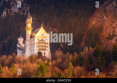 Il Castello di Neuschwanstein, Germania situato a Fussen, Bavaria durante il tramonto colorato, alleggerita con il sole Foto Stock