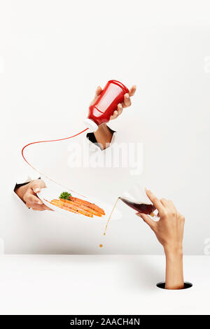 Studio shot di 3 donne la mano che esce dal fondo bianco e tavolo. Che rappresenta il brunch Foto Stock