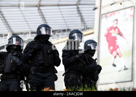 Leverkusen, Germania. Xxi Nov, 2019. I poliziotti con i caschi e le attrezzature di protezione pratica contro i tifosi di calcio e stand presso lo stadio di fronte a una foto che mostra un calciatore. Di nuovo e di nuovo gli ufficiali di polizia hanno a che fare con i più aggressivi i tifosi di calcio, in Bundesliga spesso ci sono centinaia di persone in loco. Le forze di emergenza a Leverkusen hanno provato cosa prestare particolare attenzione nel corso di tali missioni. Credito: Federico Gambarini/dpa/Alamy Live News Foto Stock