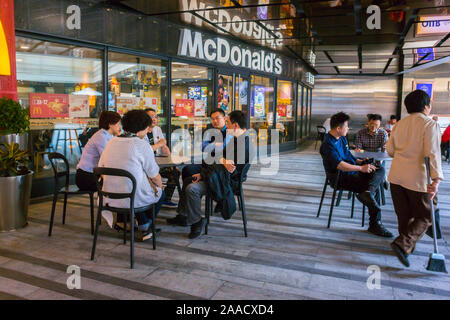 Shanghai, Cina, People Outside Tables, Sharing Meals, vista generale del mcdonald's Fast Food Restaurant nel centro commerciale Zhong hai Huan Yu Hui, Xin Tian di area, cibo globalizzato, capitalismo cinese Foto Stock