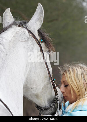 Una magica cercando girl e cavallo in un paesaggio innevato. Foto Stock
