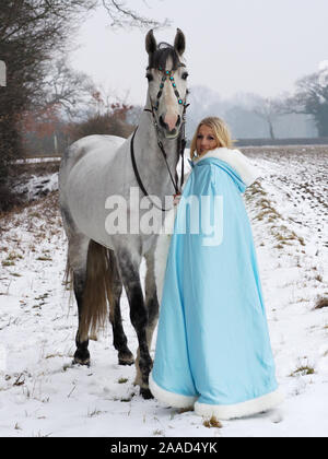 Una magica cercando girl e cavallo in un paesaggio innevato. Foto Stock
