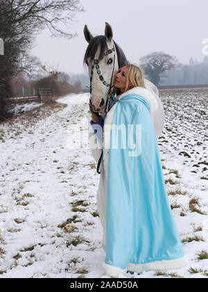 Una magica cercando girl e cavallo in un paesaggio innevato. Foto Stock