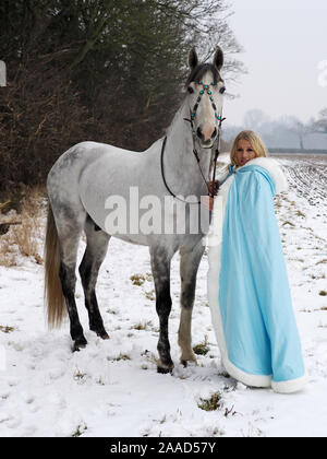 Una magica cercando girl e cavallo in un paesaggio innevato. Foto Stock