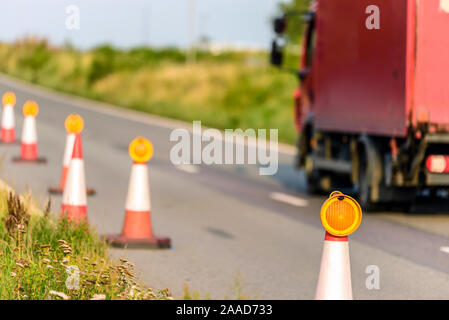 Vista tramonto uk servizi autostradali roadworks coni con red van passante Foto Stock