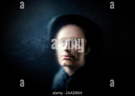 Mistero figura dietro un polveroso vetro graffiato Foto Stock