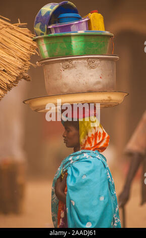 Ouled Rachid tribeswoman trascinando il campo da bocce e benne sul suo capo, Kashkasha villaggio nei pressi di Zakouma National Park, Ciad, 2010. Foto Stock