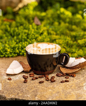 La tazza di caldo gustoso caffè di cocco sulla superficie di pietra Foto Stock