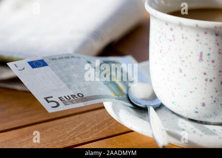 Fünf Euroschein un einer Kaffeetasse Foto Stock