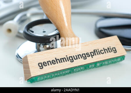 Stempel mit Aufschrift 'genehmigungspflichtig' neben Stethoskop Foto Stock