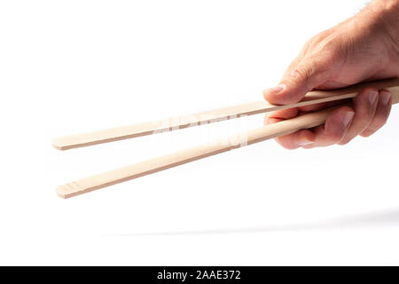 Grill in legno pinze in una mano umana isolati su sfondo bianco. Foto Stock