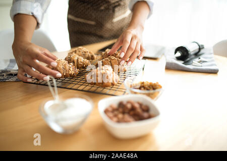 Giovane donna in cucina serve biscotti Foto Stock