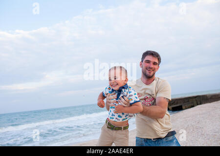 Padre avendo divertimento con il figlio sulla riva del mare Foto Stock