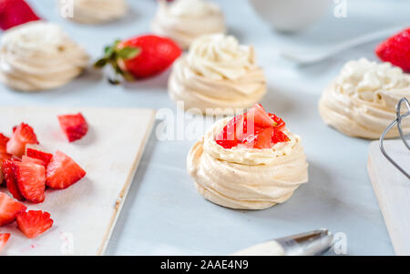 Fragola PavlovaHomemade piccola fragola pavlova meringa torte alla crema dessert con menta fresca Foto Stock