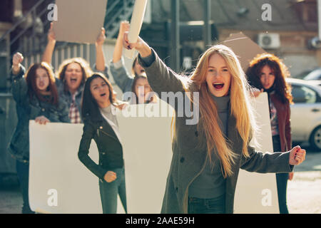 Giovane donna urlare davanti a persone che protestano circa i diritti della donna e uguaglianza su strada. Incontro circa il problema nel luogo di lavoro, pressione maschio, abuso domestico, molestie. Copyspace. Foto Stock