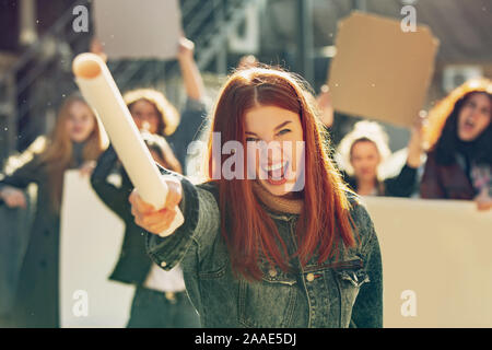 Giovane donna urlare davanti a persone che protestano circa i diritti della donna e uguaglianza su strada. Incontro circa il problema nel luogo di lavoro, pressione maschio, abuso domestico, molestie. Copyspace. Foto Stock