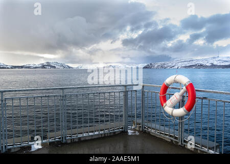 Il bianco e il rosso salvagente su un ostacolo sul posto barca contro lo sfondo del nord con vista sul mare Foto Stock