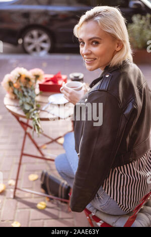 Donna felice avente una pausa caffè da solo Foto Stock