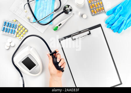 Close-up di tonometro dal braccio di pazienti durante la misurazione della pressione del sangue in consultazione medica Foto Stock