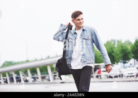 Giovane uomo bello con un sacchetto sulla sua spalla in fretta all'aeroporto Foto Stock