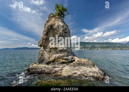 Ampio angolo di visione di Siwash Rock visto dalla parete del mare, Stanley Park, Vancouver, Canada. Cieli drammatici, English Bay, West Vancouver in background. Foto Stock