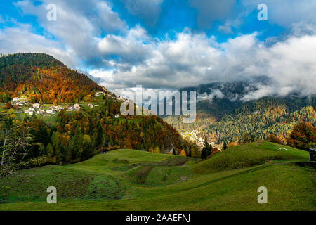 Colorato aumtumn vista su tutta la valle del Cordevole con Avoscan, Pecol e Piaia villaggi in background in Belluno, Italia Foto Stock