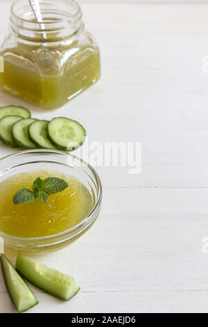 Verde marmellata di cetriolo in una ciotola di vetro su uno sfondo bianco. Foto verticale con posto per il testo. Foto Stock