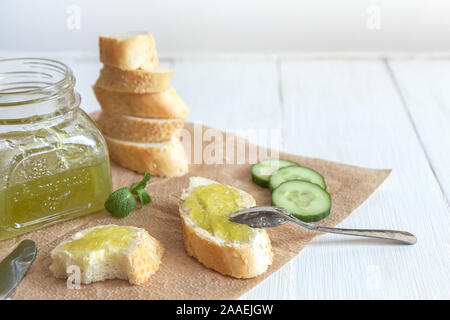 Panini per la colazione con il cetriolo marmellata, burro, baguette su uno sfondo bianco. Foto orizzontale con copia spazio. Foto Stock