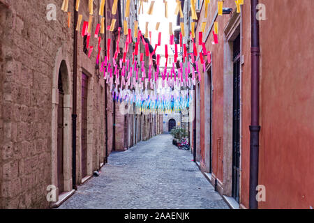 Carta colorata flags over street. Garland decorazione presso la fiera. Decorazioni colorate di bandiere colorate del festival. Le stringhe con bandiere. L'Italia. Foto Stock