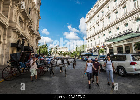 Carrozze trainate da cavalli in Manzana de Gómez square a l'Avana Foto Stock