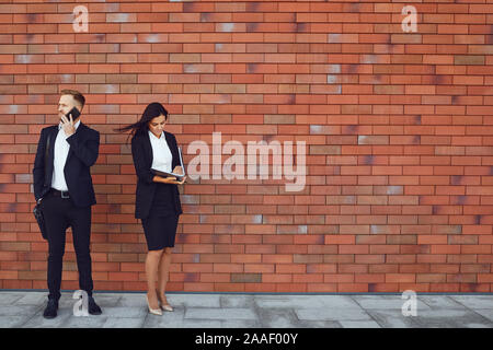 Gli imprenditori stand su un muro di mattoni dello sfondo. Concetto di lavoro business professional meeting. Foto Stock