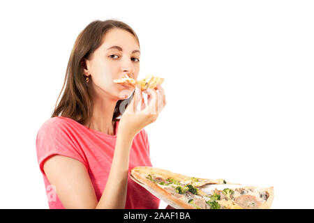 Giovane donna mangia la pizza su sfondo bianco, guardando la fotocamera Foto Stock