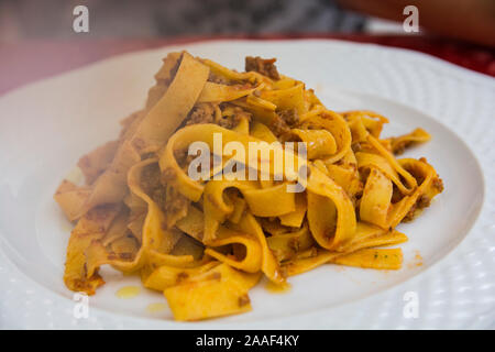 Un steamy tradizionale 'Tagliatelle Ragu', Pasta con carne macinata salsa, servita in una piastra bianca Foto Stock