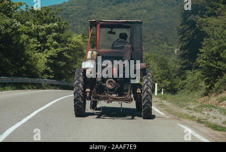 Vecchio trattore su strada in Georgian montagne Foto Stock
