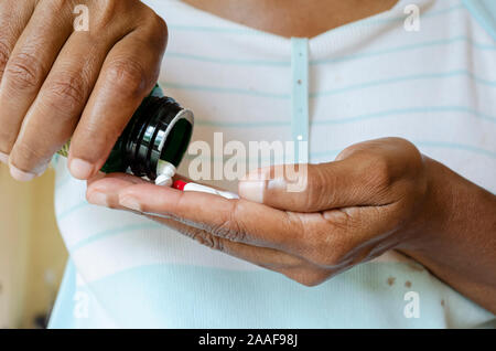 Versando il compresse dalla bottiglia Foto Stock