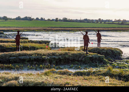 Sagome di metallo WW1 soldati guardare attraverso il paesaggio. Papaveri ai loro piedi. Un ricordo omaggio agli uomini che hanno perso la loro vita in WW1. Foto Stock