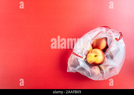 Sacchi di materia tessile con pesche e riutilizzabili di borse per lo shopping per il negozio di generi alimentari, ecologico rifiuti zero e dire di no ai concetti di plastica Foto Stock