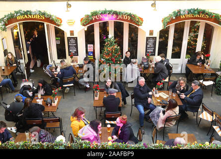 Seduto fuori il punzone e Judy xviii secolo pub di Covent Garden, nel tempo di Natale, a Londra, Regno Unito Foto Stock