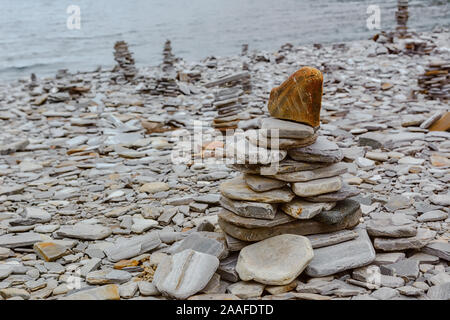 Touristic piramide stack equilibrata di pietre sulla spiaggia nel modo di Nordkapp, Norvegia Foto Stock